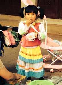 Cute Bai girl at market in traditional dress